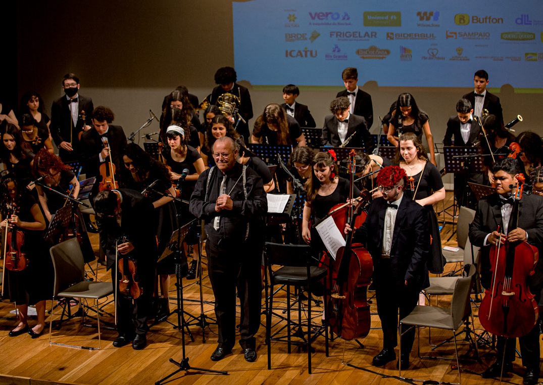 Orquestra infantil toca música em piano de instrumento escolar e